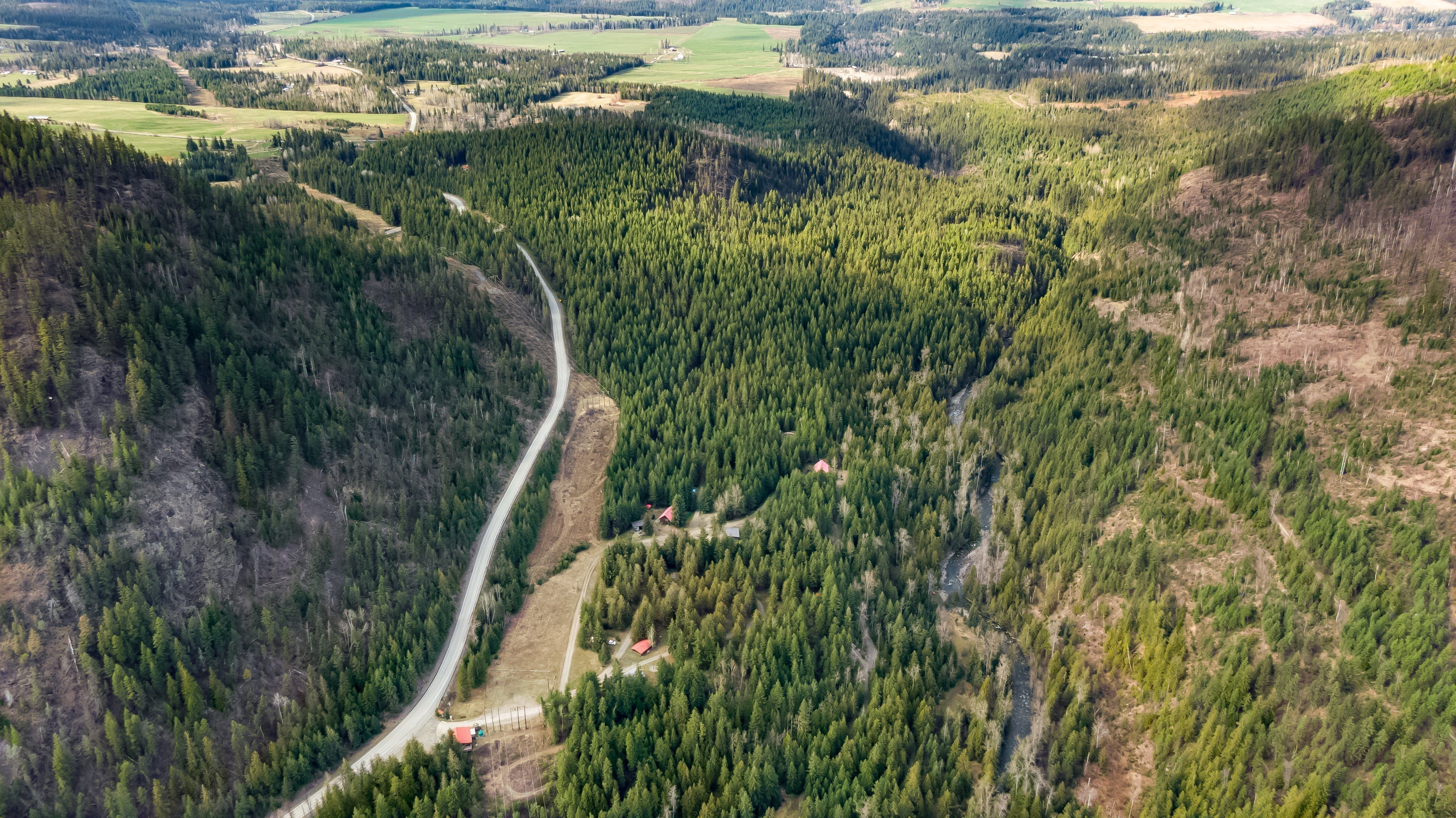 An aerial view of Gold Panner Campground in Cherryville BC - a highway running through a densely forested valley